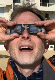 Author David Baron looks through eclipse glasses